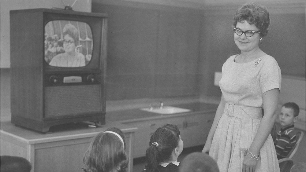 Photo of teacher with students on set in the 1950s