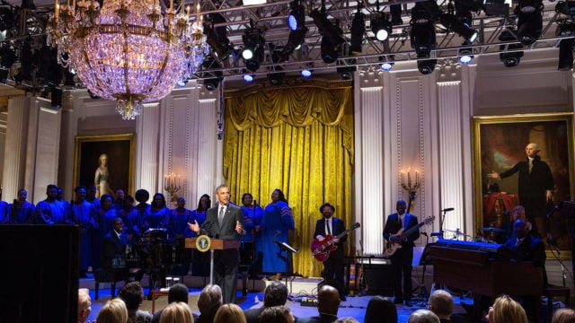 Image of President Obama at the White House with musicians and choir on stage