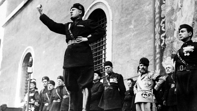 Mussolini giving a speech with fist in the air