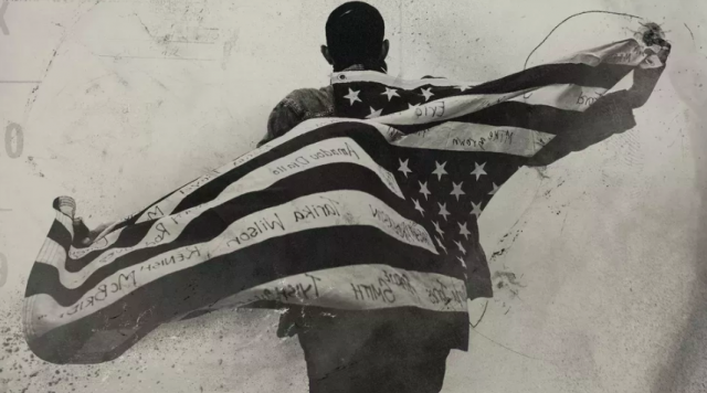 Image of man with American Flag draped across his back