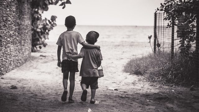 Two young boys walking down a path