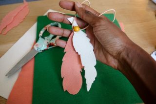 Boy making a feather necklace craft