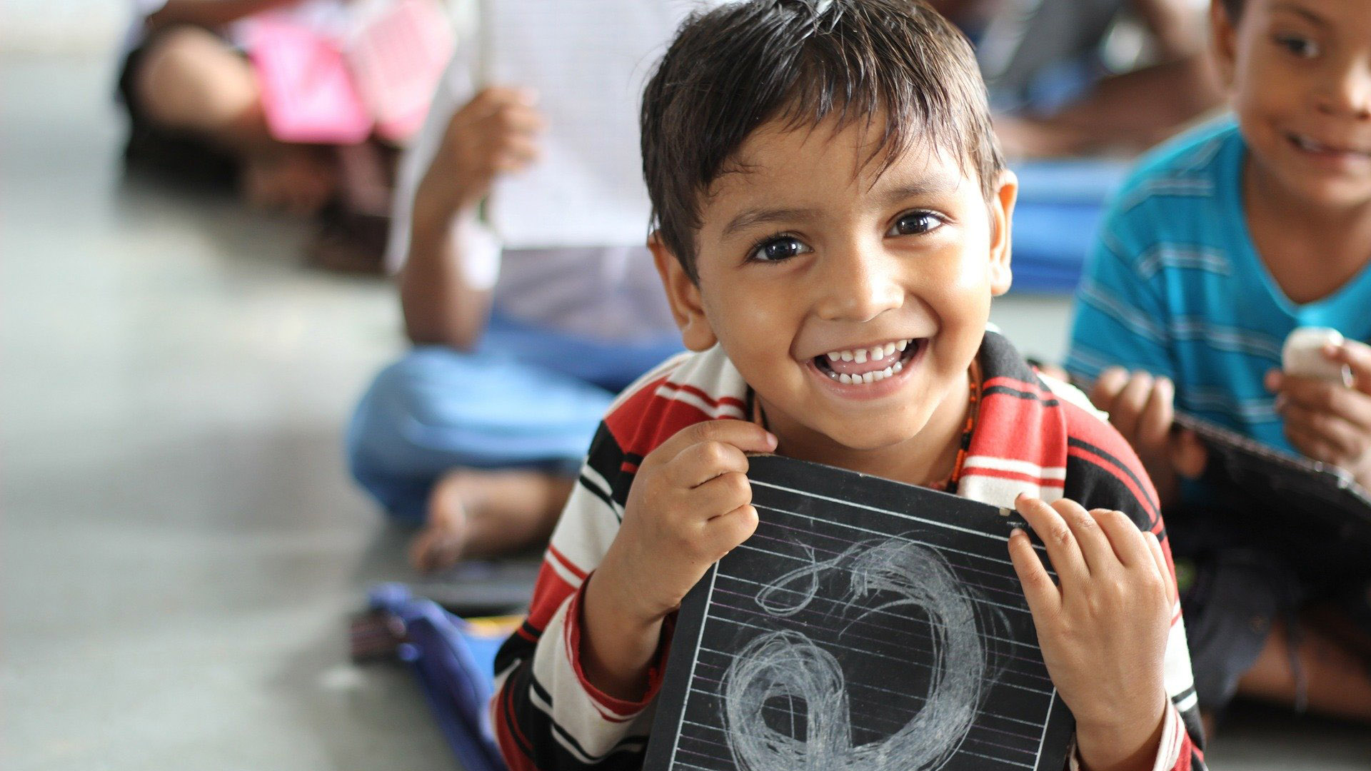 Boy at school holding a chalkboard