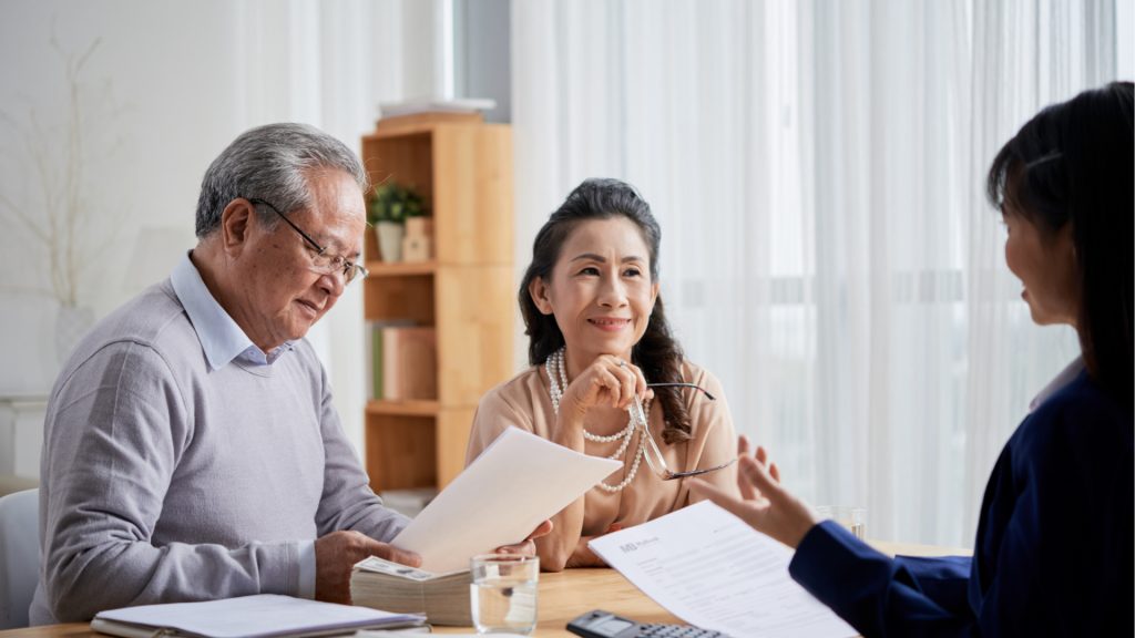 older couple meeting with woman holding papers