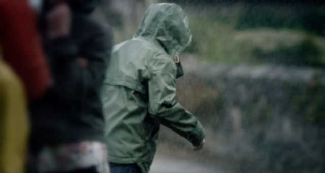 boy in green jacket in rain