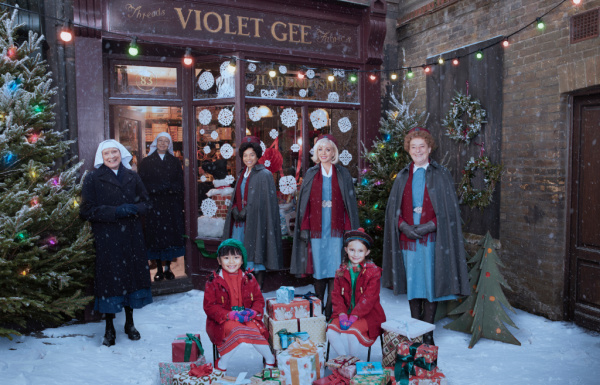 nurses and children outdoors with christmas lights