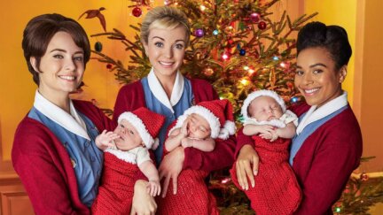 three nurses holding babies in Christmas stockings