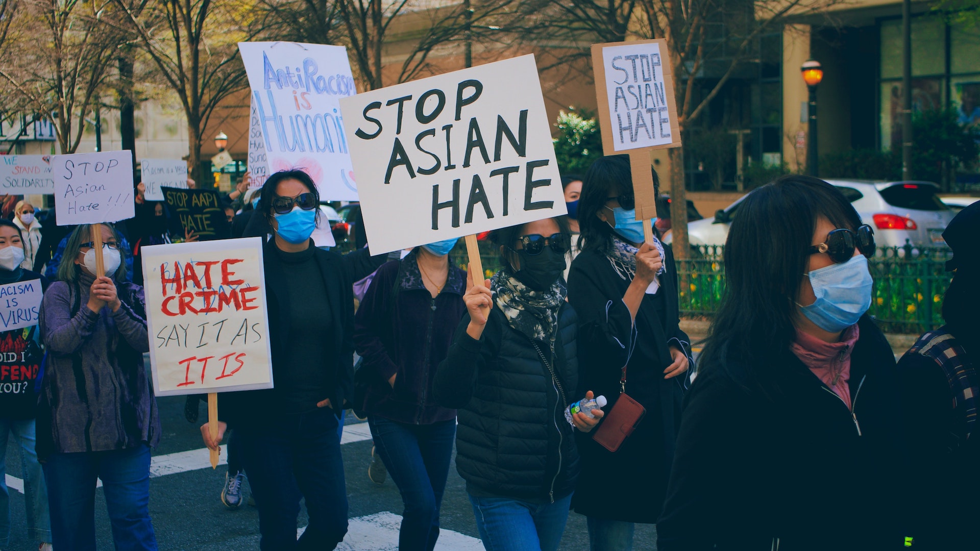 People holding up protest signs that read "Black & Asian Solidarity" and "Stop Asian Hate"