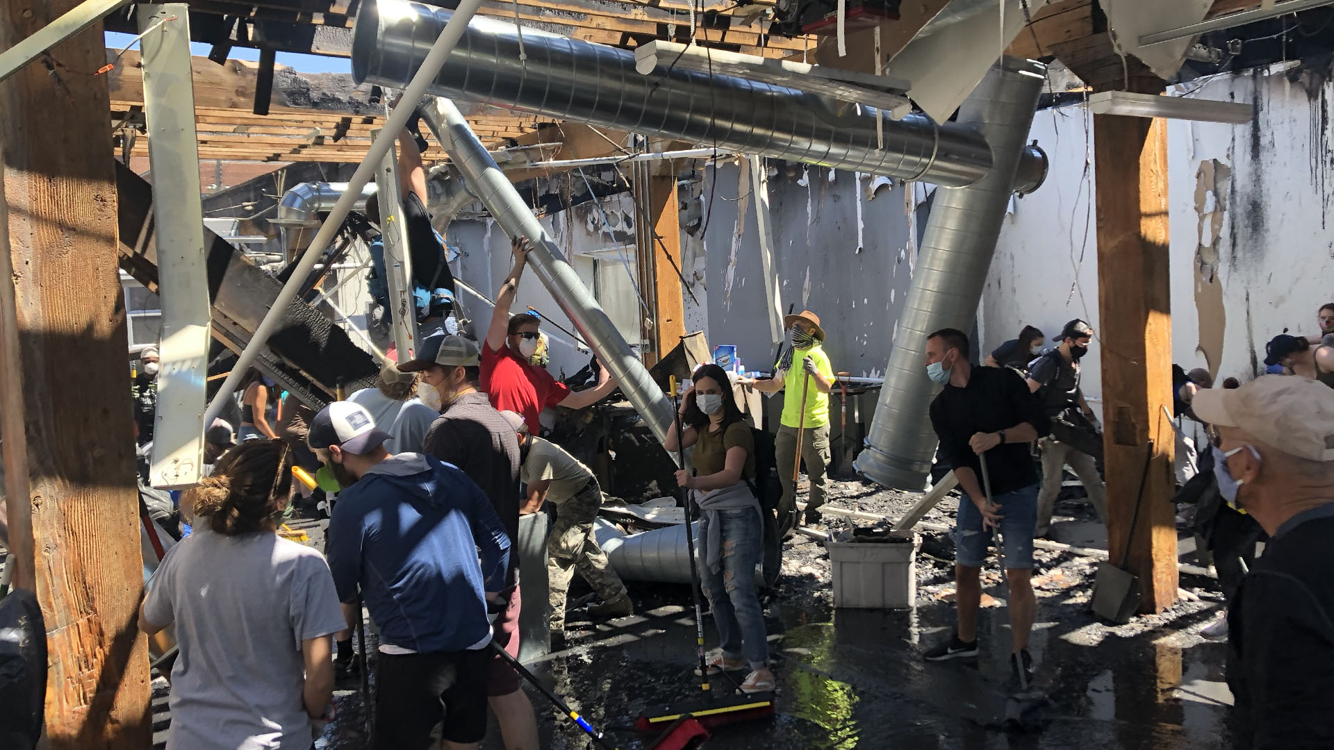 People cleaning up burned building