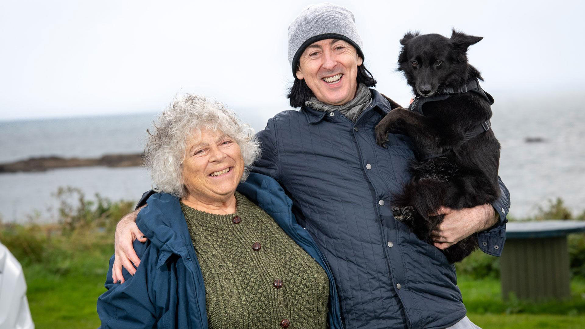 Miriam and Alan smile together with a cute dog.