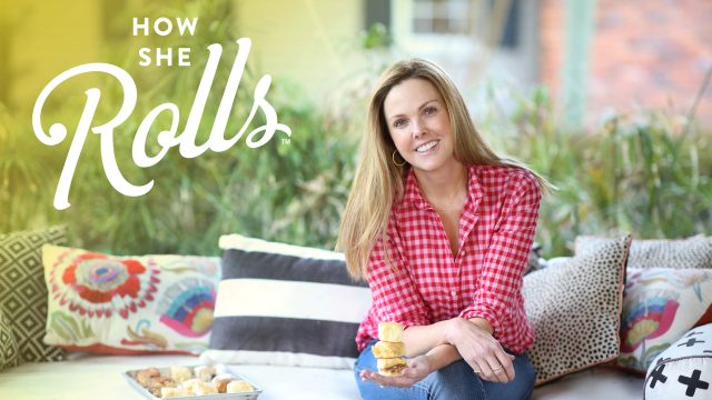 Carrie Morey smiles at the camera holding fresh made rolls.