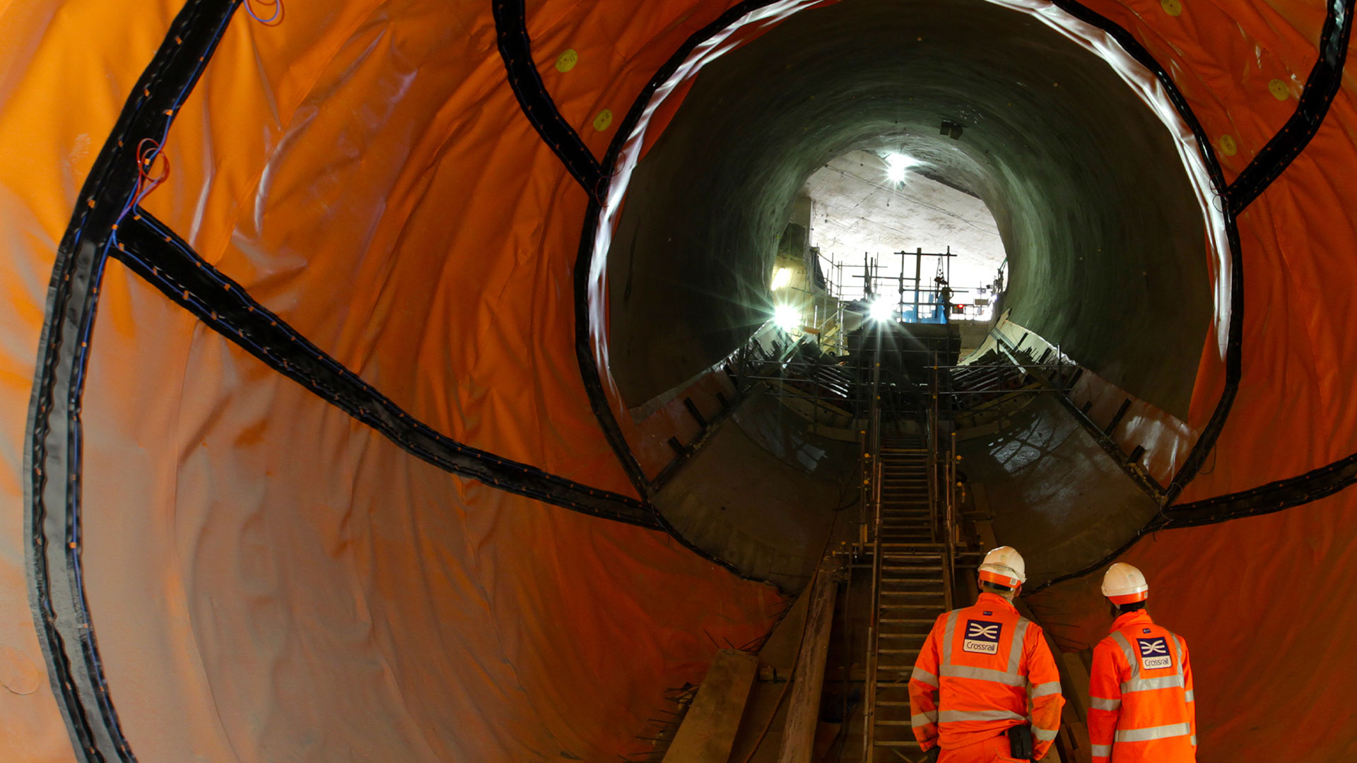 Engineers stare down an underground tunnel in construction
