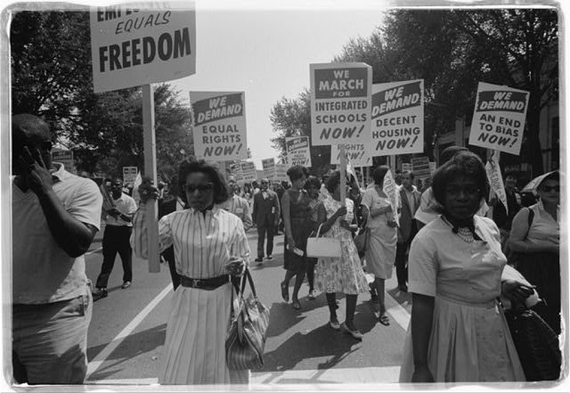 a large group of black men and women holding signs advocating for civil rights