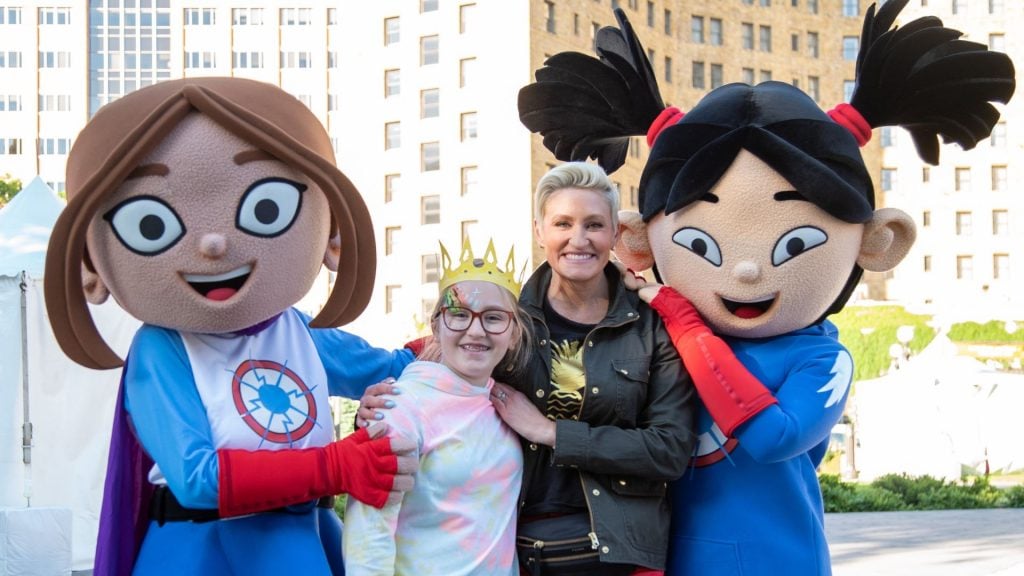 Lucita Sky and Sara Snap of Hero Elementary standing next to child and woman while smiling