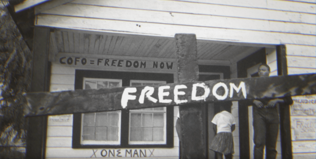 black and white photo of house with a sign that reads freedom